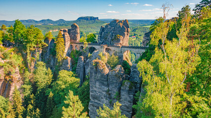 Cover page with birdview over Bastei sandstone rocks and ancient bridge near Kurort Rathen village in the national park Saxon Switzerland by Dresden, Saxony, Germany.