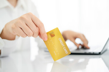 Asian young woman resting and browsing internet with Laptop holding credit card online shopping concept