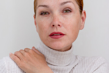 Portrait of cropped caucasian middle aged woman face with freckles on white background looking at...