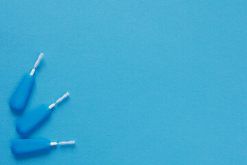 Top view of little dental toothpick brush on blue with copyspace