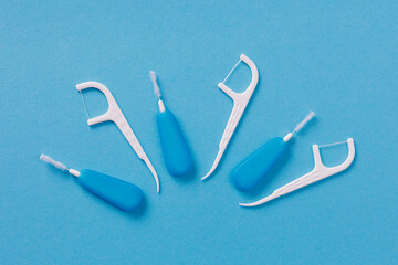 Top view of dental floss picks on blue background