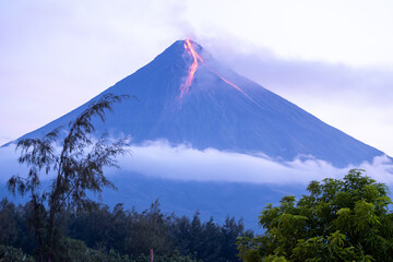 volcano erupting at sunrising spewing lava - obrazy, fototapety, plakaty
