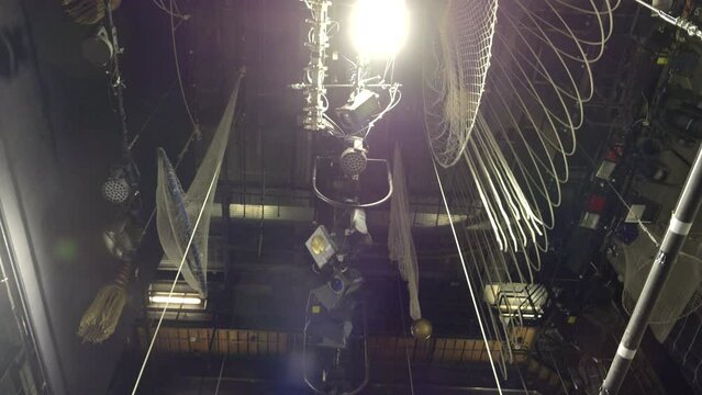 Old theater, stage lighting, and ropes hanging above the stage