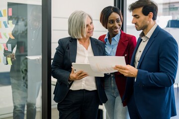 Group of colleagues discussing documents in office