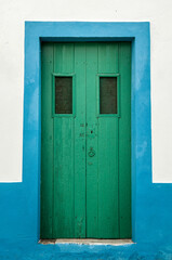 green wooden doors in a blue and white wall, Portugal
