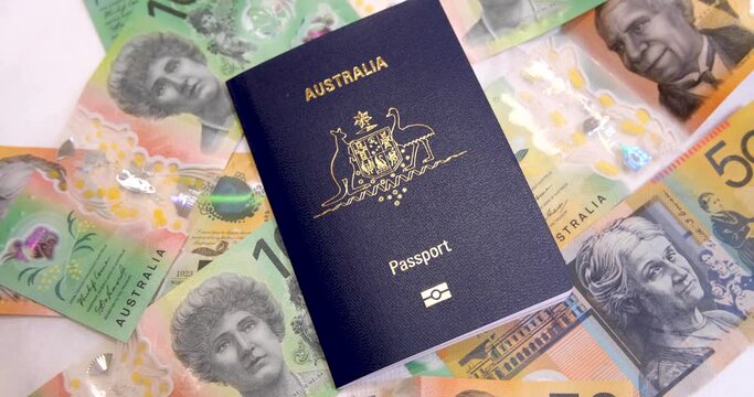 A new Australia passport placed on a pile of Australian dollars cash. Concept of savings for travelling overseas, cost of international trip, expense of stay away, allowance and budget on the road.