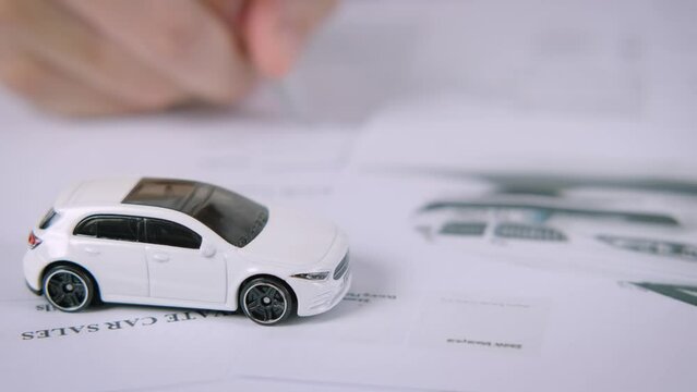 Buyers or sellers who are reading car lease or car insurance contract and signing. Sale agent deal to agreement  car loan contract with customer and sign agreement contract, car Insurance concept.