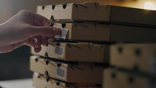 Pizzeria, Shef chef baker Carefully glues barcode pizza box at baker's workplace In slow motion Professional chef's assistant Cooking process in the kitchen of a fast food restaurant, handmade
