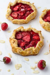 Mini biscuits with strawberries. Small berry pies on a white background.