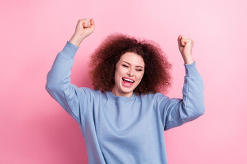 Photo of young overjoyed shopaholic girl wear blue sweatshirt fists up new collection cheap clothes...