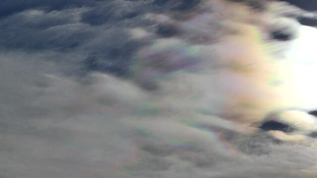 Natural blue sky with colorful decorative clouds moving very slowly - Cloud iridescence, irisation around sun. Observed in warm, sunny, windy autumn weather with mountain winds on October in Poland.