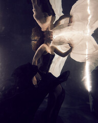 girl under water with fabrics fantastic fabulous look on dark background