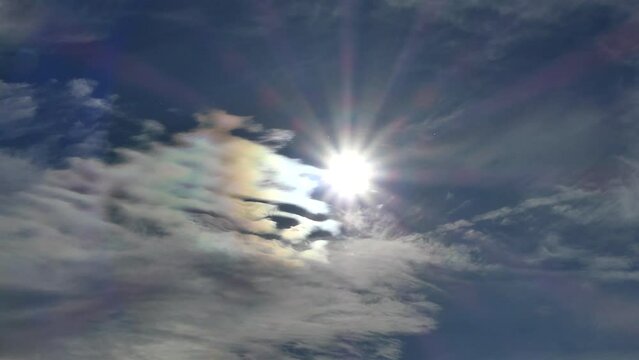 Natural blue sky with colorful decorative clouds moving very slowly - Cloud iridescence, irisation around sun. Observed in warm, sunny, windy autumn weather with mountain winds on October in Poland.