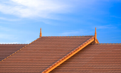 Fototapeta na wymiar 2 levels of Brown ceramic tile roof in vintage style against blue sky background 
