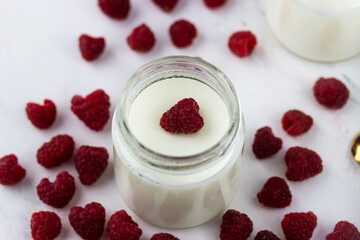 Homemade yogurt with raspberries. Jars of yogurt surrounded by raspberries. Top view
