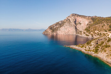Aegean coast of Turkey with rocky shore with deep blue water. aerial wide shot
