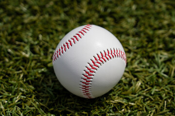 Baseball white ball lies on a green lawn
