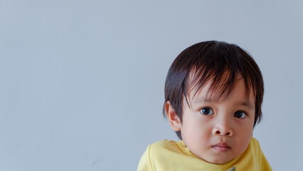 potrait of cute little asian boy wearing yellow shirt