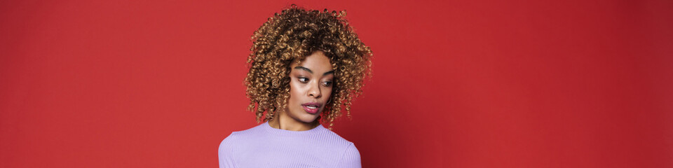 Young black woman with afro curls posing at camera