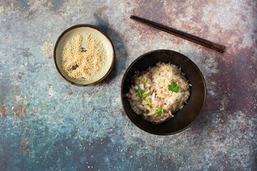 Tuna salad mayonnaise sesame has brown rice in black bowl on metal table.