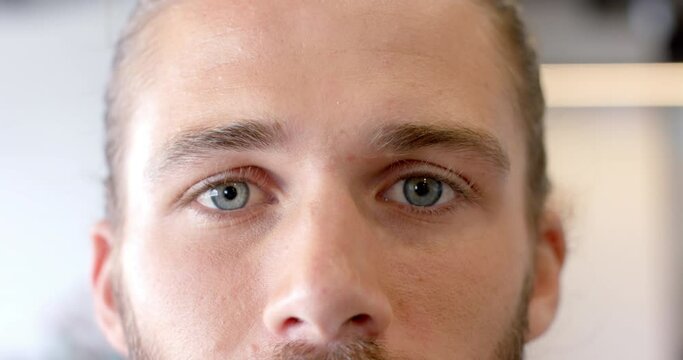 Portrait close up of happy caucasian businessman opening blue eyes smiling in slow motion
