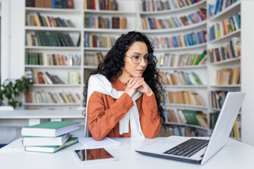 Young serious female student thinking about a solution to an assignment, studying remotely while...