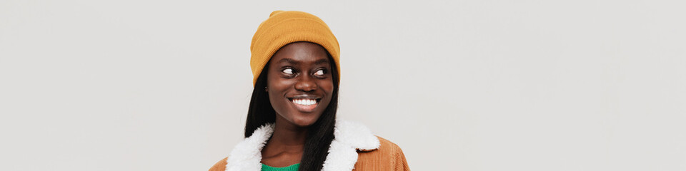 Young beautiful long-haired smiling african woman in winter hat
