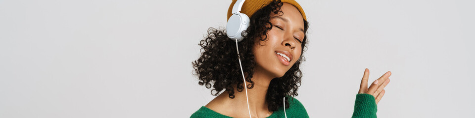 Black woman wearing hat dancing while listening music