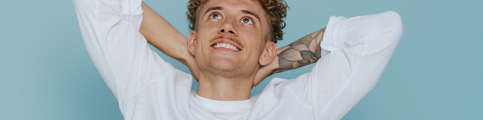 Obraz premium Portrait of young handsome curly smiling man with mustache