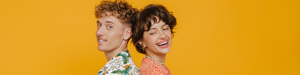 Young smiling man and happy woman standing back to back