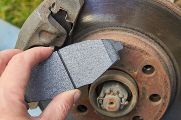brake pad in the hands of a car mechanic,on the background of a car brake disc in the hands of the front brake pads © retbool