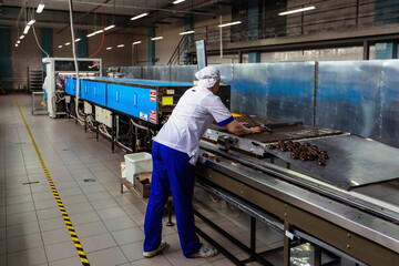 Confectionery worker sorting zephyrs on conveyor