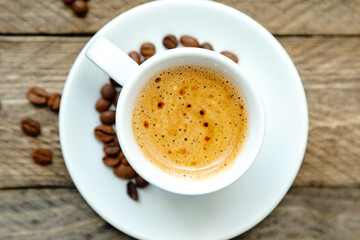 Cup of freshly brewed coffee on a wooden background.