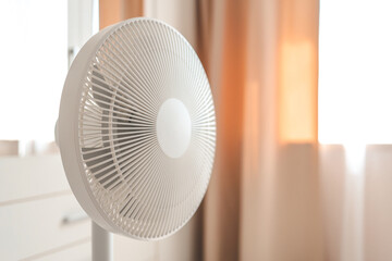 White desktop electric fan on light white room. Minimal concept with copy space