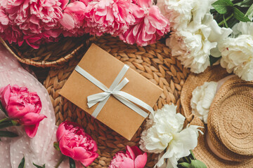 Gift box with bow and pink peonies, holiday concept