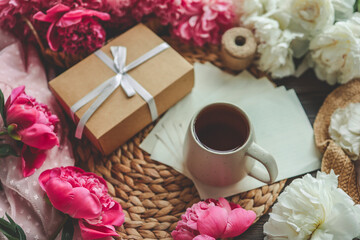 Beautiful spring composition, good morning concept. Cup of tea, peonies, gift box