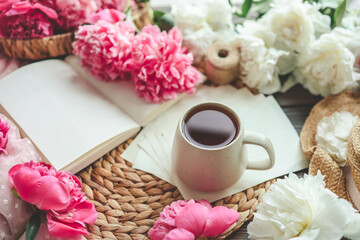 Obraz na płótnie Canvas Beautiful spring composition, good morning concept. Cup of tea, peonies and open book