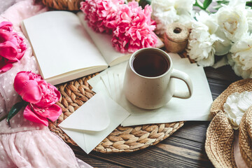 Beautiful spring composition, good morning concept. Cup of tea, peonies and open book