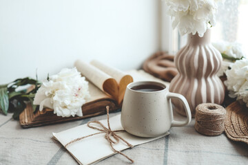 Vintage still life on the windowsill, a cup of tea and peonies