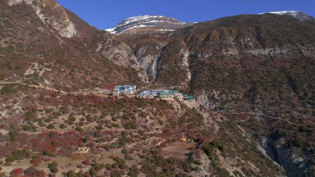 Aerial zoom in view house buildings complex in Himalayan mountains hilltop. Trekking Tilicho base camp trail. Accommodation guesthouse architecture, tourism business concept