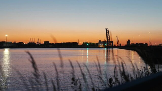Orange sky and sunset over cargo seaport with roro vessel in the background