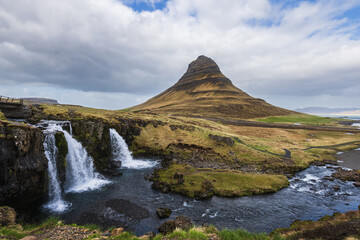 The iconic mountain kirkjufell in west iceland on the peninsula scaefellsnes in summer with the waterfall kirkjufellsfoss in front