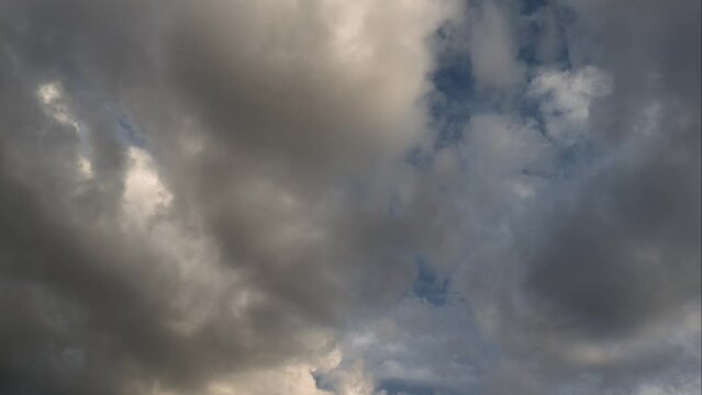 Golden cumulus clouds in the sky moving in a heavenly landcape at sunset