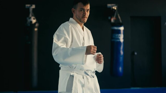 Focused taekwondo practitioner practicing kicks in martial arts school, training