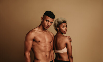 Confident couple showing off their fit physique and melanin glow