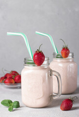 Homemade smoothie with strawberries in Mason jars with drinking straws, Vertical format