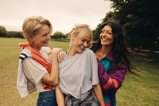 Three women enjoying a playful day outdoors in the park