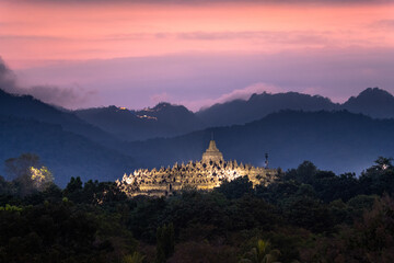magnificent borobudur temple at sunset with mountain range in background - obrazy, fototapety, plakaty