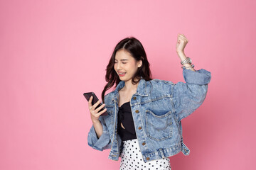 portrait asian young Women are happy while using smartphone isolated on pink background