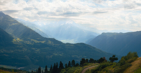 View of mountain tops, warm summer day, clouds in the sky, way to Ushba mountain and Koruldi lakes. Concept of vacation and travel to Georgia. Nature, Mestia, Svaneti mountains